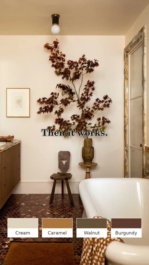 Illustrative cream bathroom with caramel and walnut tones and a dark burgundy foliage accent.
