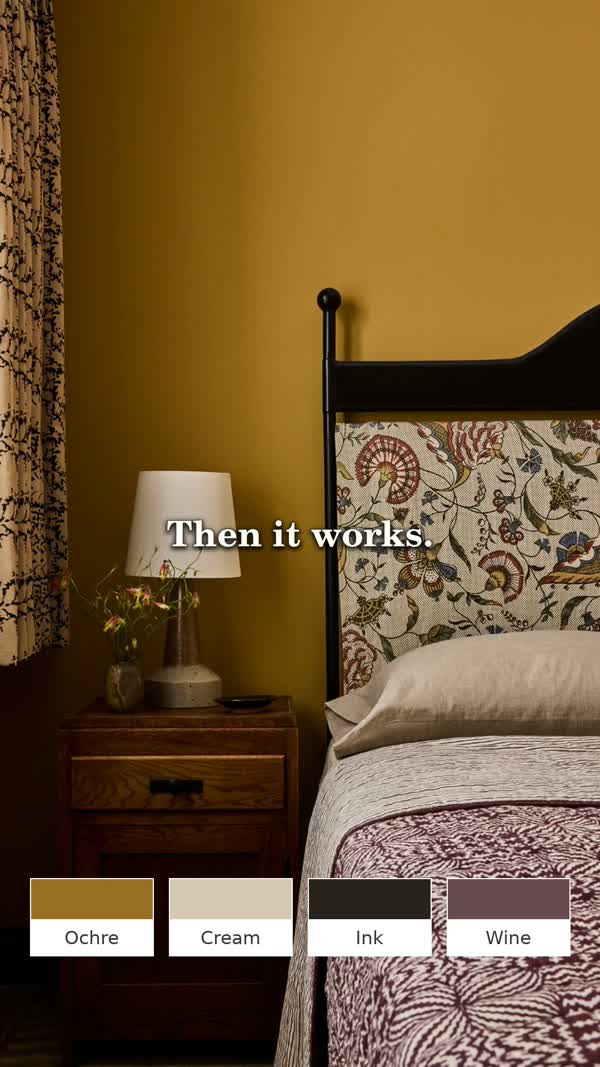 Illustrative ochre bedroom with a dark bed frame, cream bedding and wine-coloured textile details.